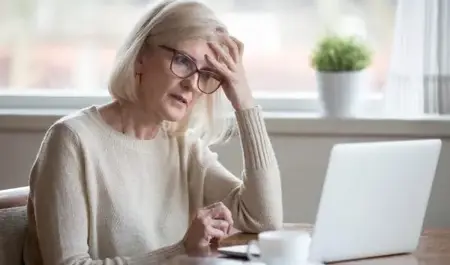 A woman sitting looking lonely at a computer