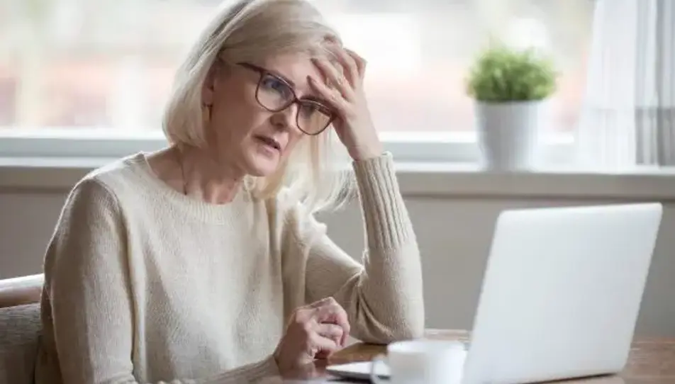 A woman sitting looking lonely at a computer
