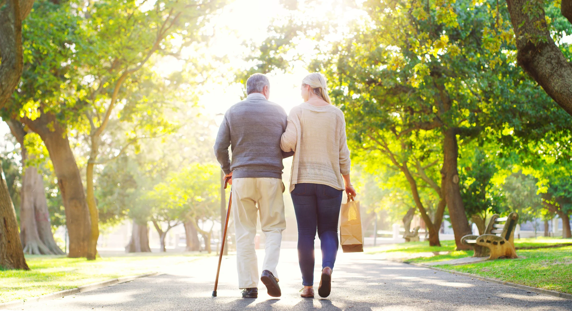 Man with COPD being cared for on a walk by his daughter