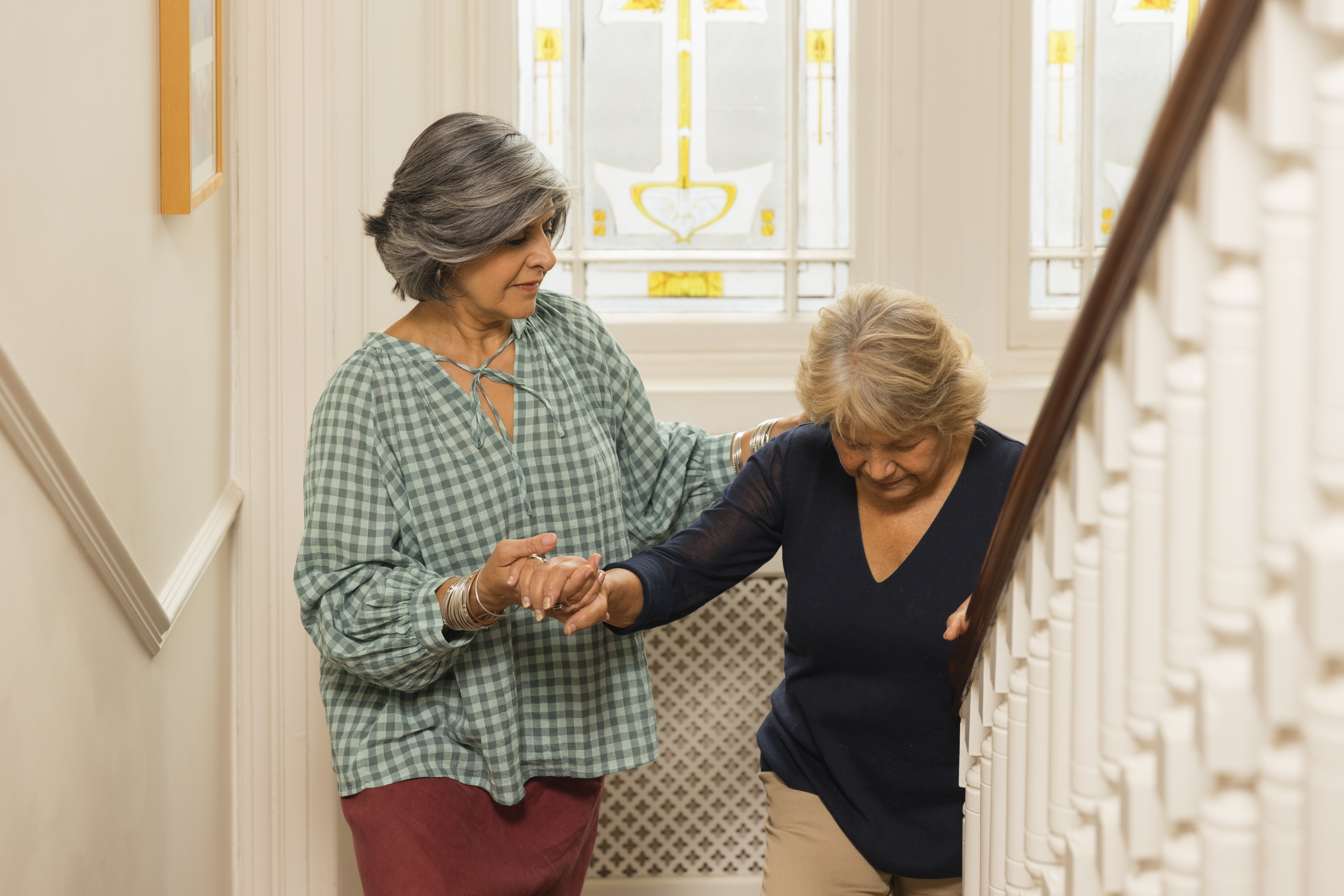 Image of a carent helping their elderly parent up the stairs, but who is looking after their health?