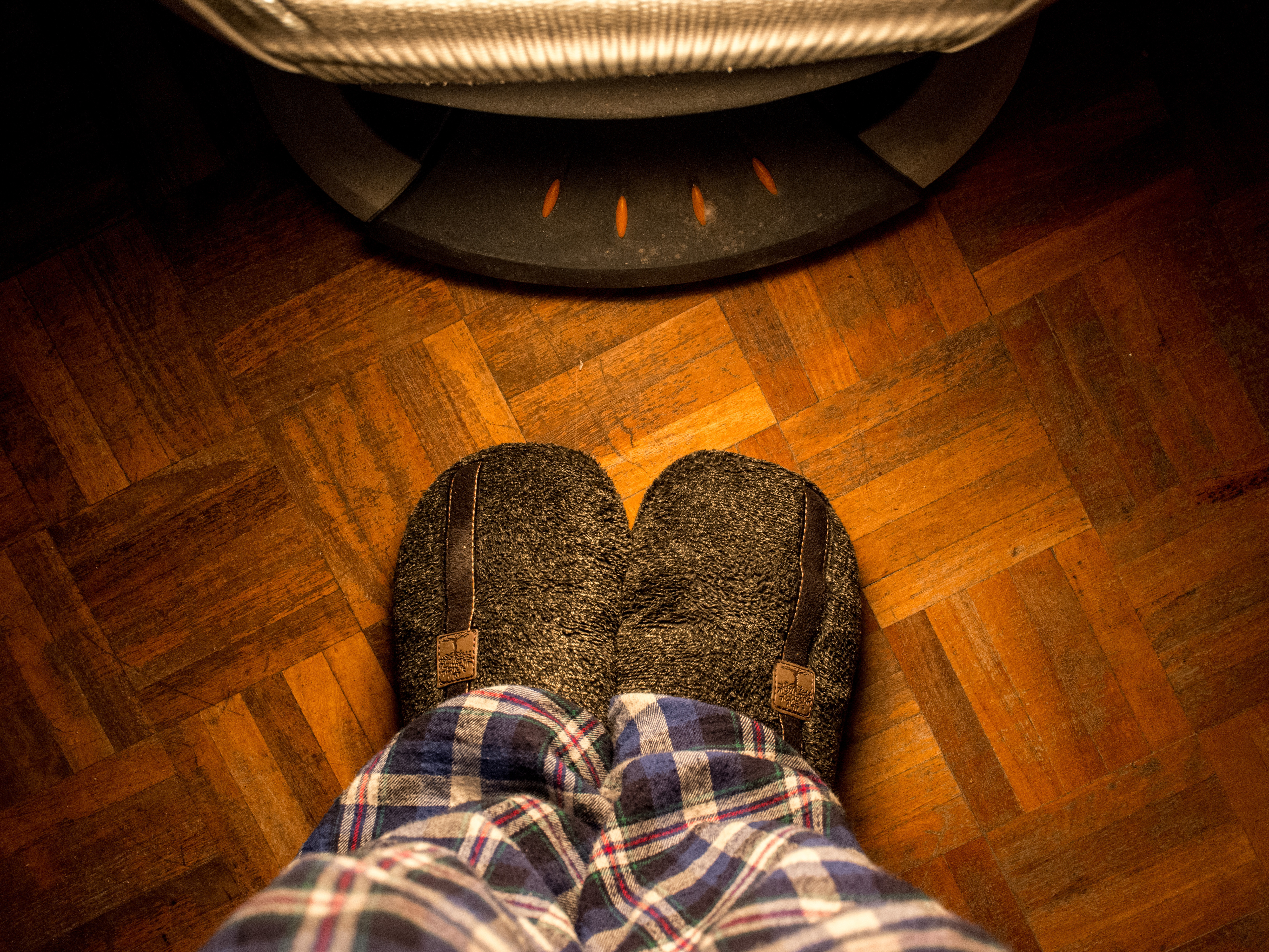 Close-up of an older adult wearing warm, cushioned slippers indoors – comfortable slippers help elderly parents stay steady on their feet while keeping warm, especially on hard flooring.