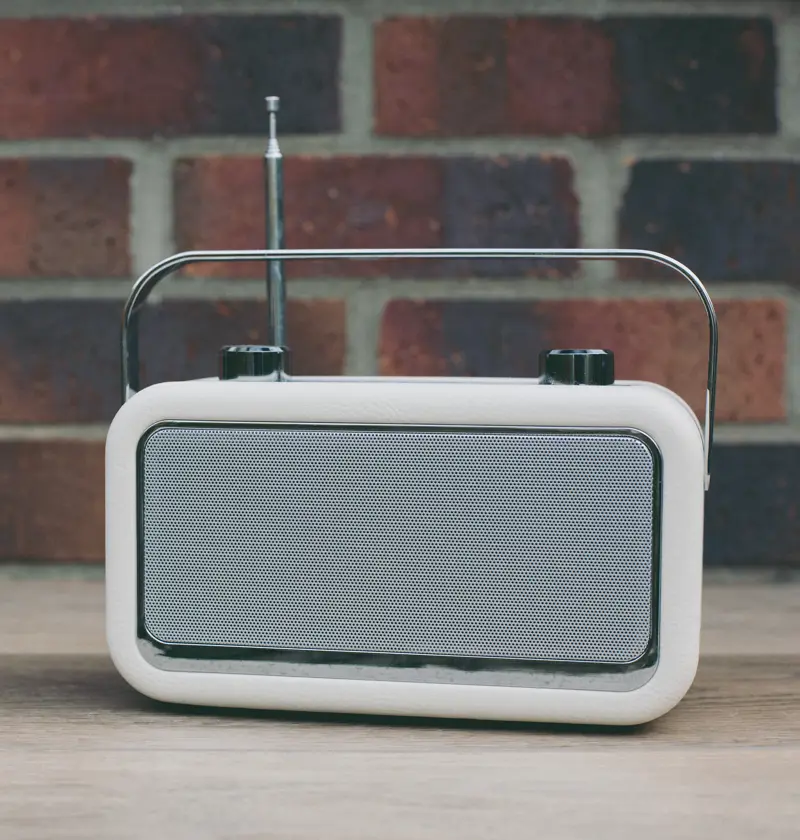 Simple digital radio music player on a wooden table – easy-to-use music players support elderly parents with dementia by offering familiar sounds, soothing routines, and a sense of connection.