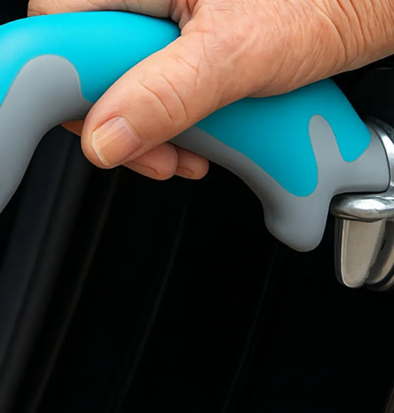 Hand holding a car door assist handle – designed to help elderly parents get in and out of vehicles more safely by providing a stable grip and extra support during transfers.