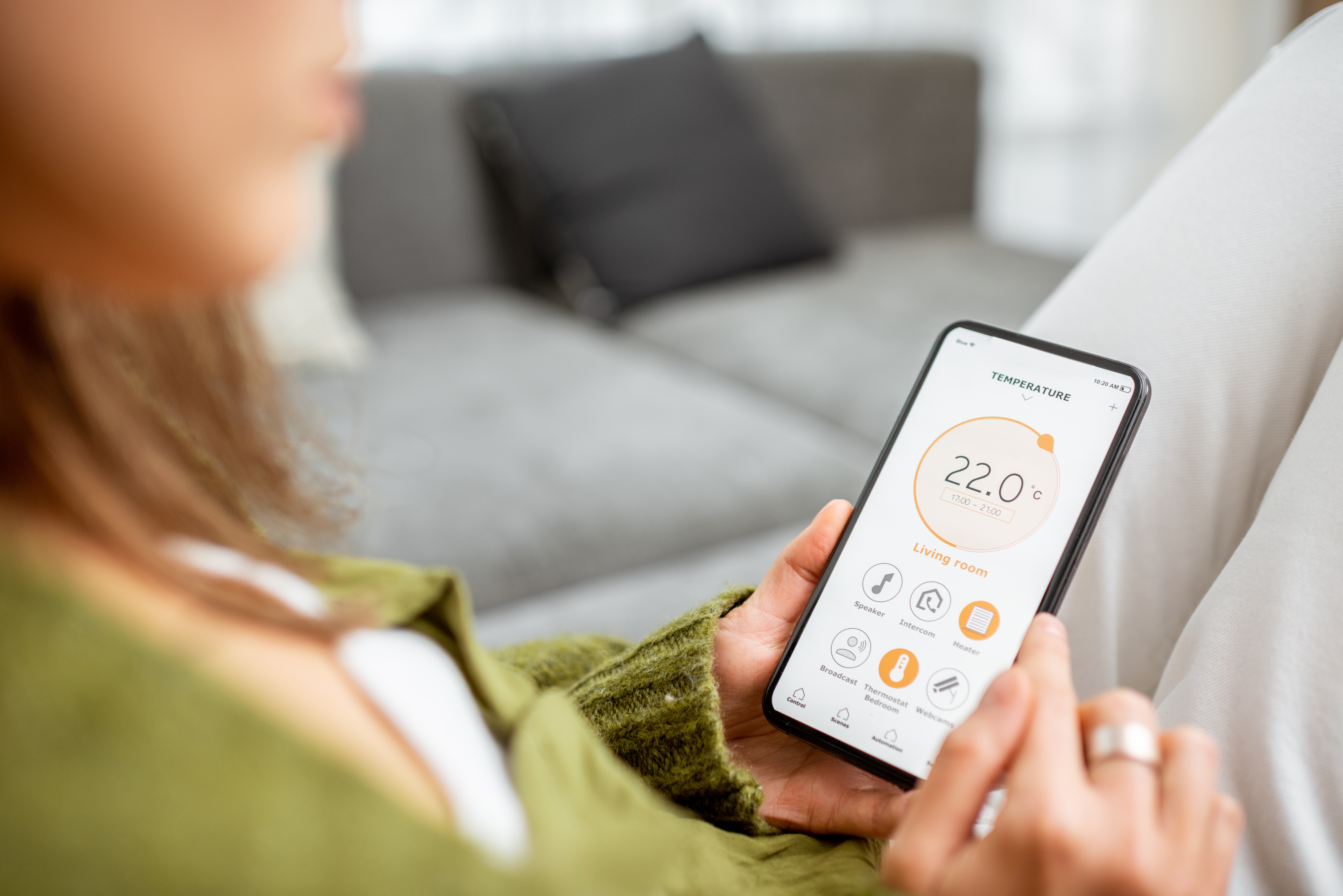 Someone reading their thermostat on their phone. Smart heating system. Representing heating, energy awareness, bills and PSR entitlement for your elderly parent.