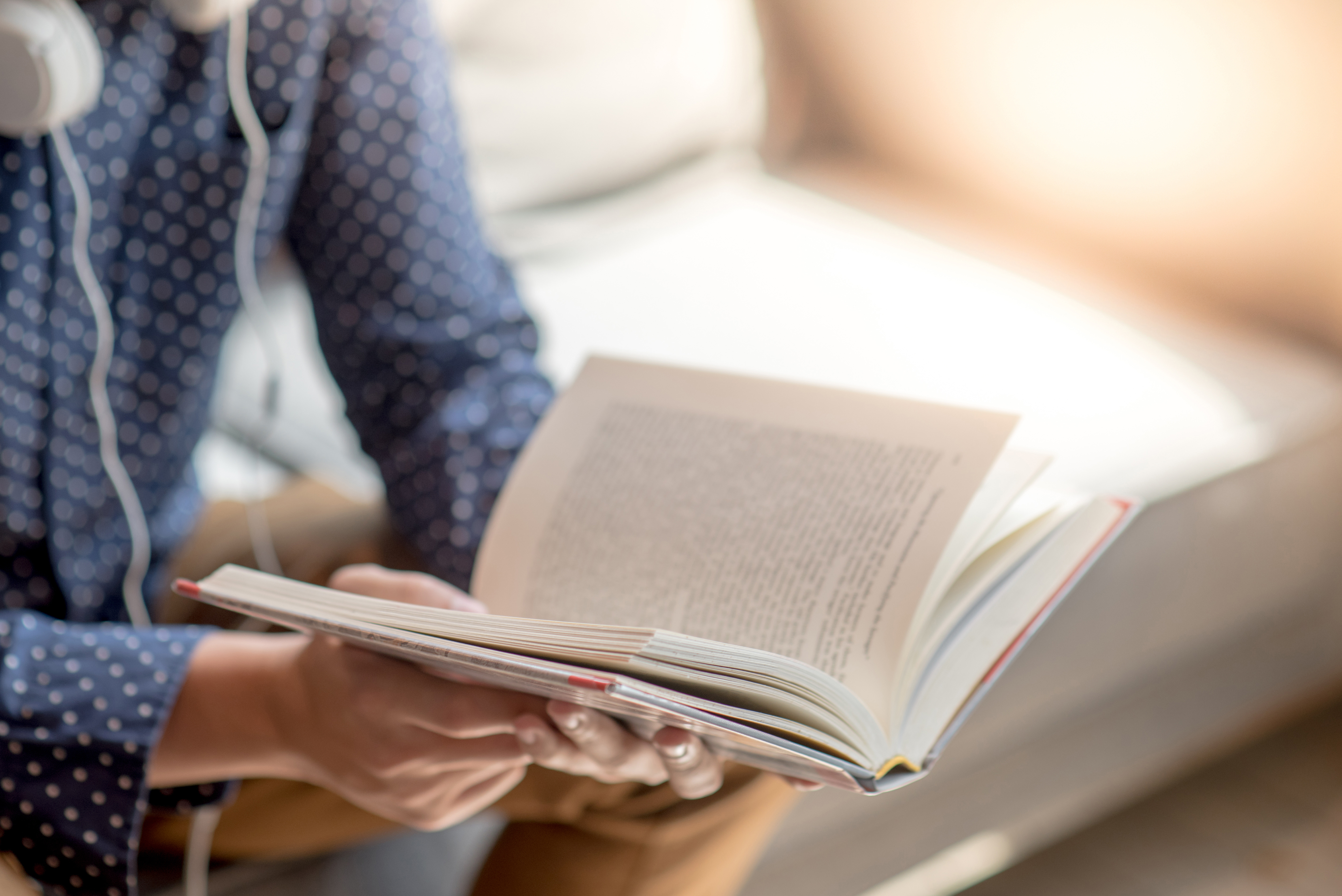 Person reading a book to learn more about caring for an elderly parent