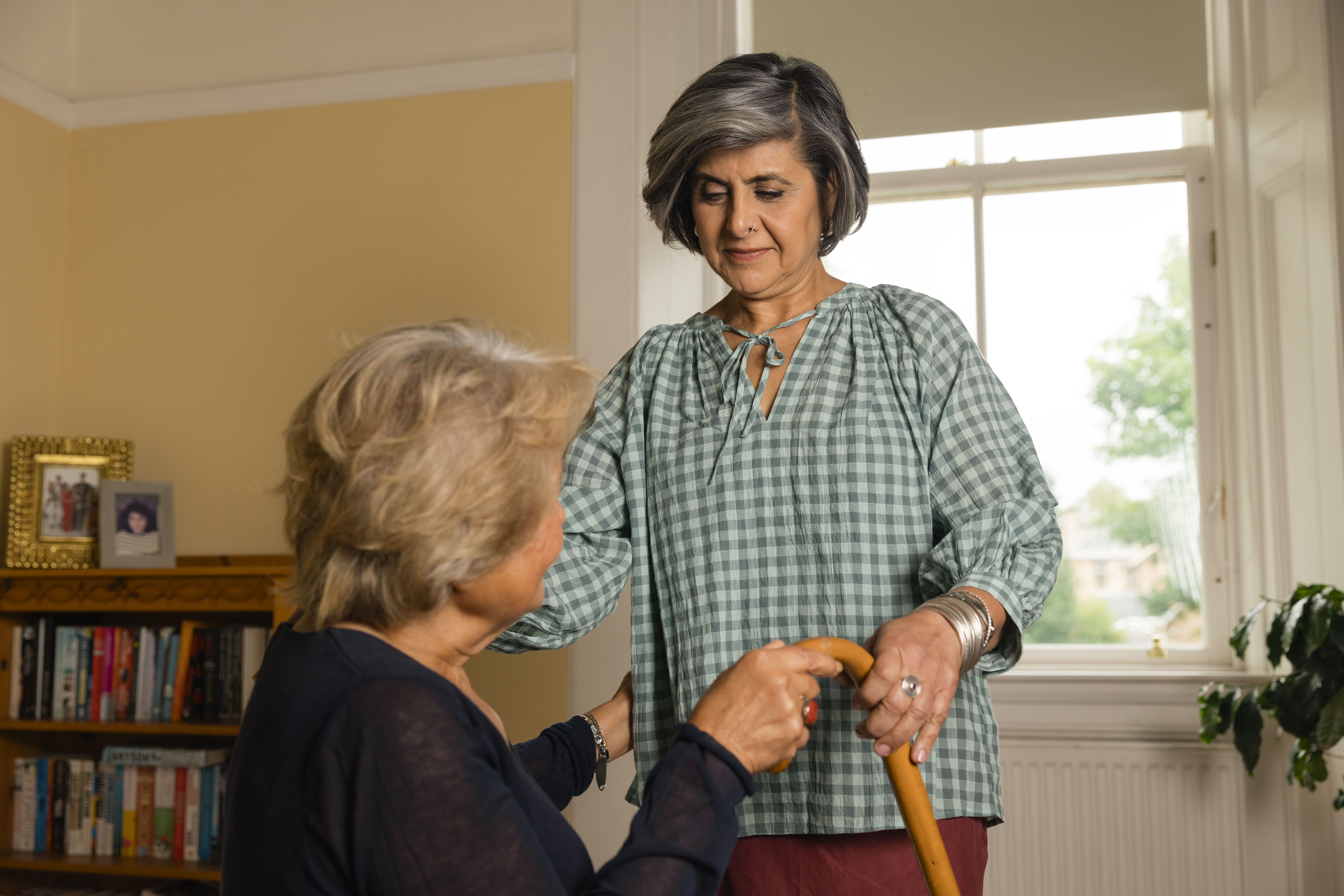 Carent providing support for their elderly parent with worry on their face