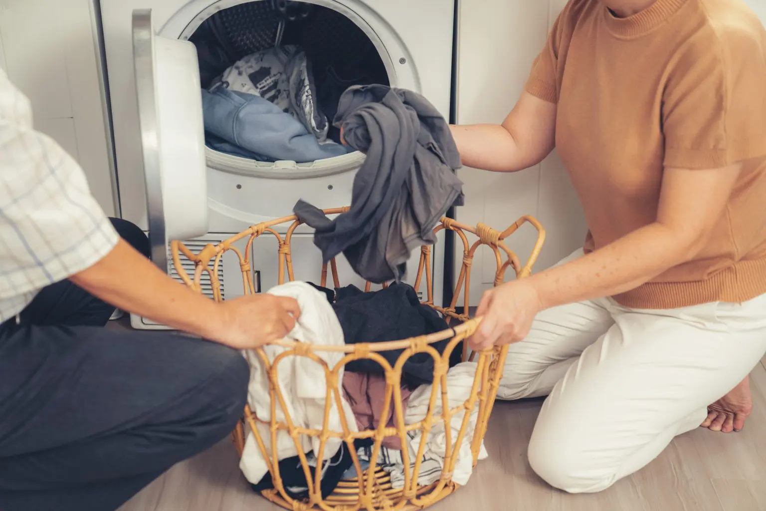 Two women loading washing into a washing machine